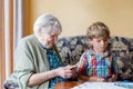 Active little preschool kid boy and grand grandmother playing card game together at home Royalty Free Stock Photo