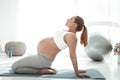 Active long-haired woman with ponytail arching her back during yoga