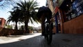 Active male bicycler rides and jumps on his bike on silver metallic handrails