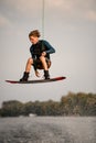 Active male wakeboarder in wetsuit jumping high over river water Royalty Free Stock Photo