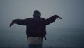 Active man dancing headphones on foggy beach. Guy making dance wave with hands