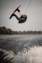 active man doing extreme high jump on wakeboard over splashing river wave Royalty Free Stock Photo