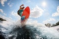 Active man jumping on bright wakeboard down the river against the background of sky Royalty Free Stock Photo