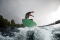 Active man jumping on bright wakeboard down the river water Royalty Free Stock Photo