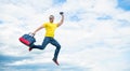 Active man jumping with travel bag midair sky background, copy space Royalty Free Stock Photo