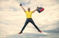 Active man jumping with travel bag midair sky background, vacation Royalty Free Stock Photo