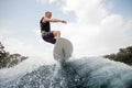 Active man jumping up on the white wakeboard on the high wave Royalty Free Stock Photo