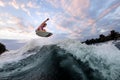 Active man jumps high above the wave on the surf style wakeboard. Summertime leisure Royalty Free Stock Photo