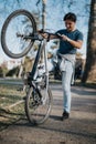 Active man lifting a mountain bike in a sunny park setting Royalty Free Stock Photo