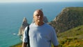 Active man looking spot for yoga workout at amazing summer cliff ocean view. Royalty Free Stock Photo