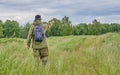 Active man in mosquito suit with backpack in hiking in a meadow. Siberia, Russia