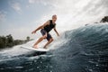 Active man riding on the white wakeboard on the high wave Royalty Free Stock Photo