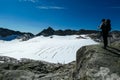 An active man standing on a rock with view on the glacier of Hoher Sonnblick in Hohe Tauern in Carinthia, Salzburg, Austria