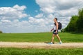 Active man tourist walking on the trail with backpack and water bottle in hand, outdoor