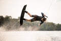 active male wakeboarder doing somersault in the air above water Royalty Free Stock Photo