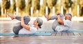 Senior couple  in sportswear lying on mat hugging her knees after yoga practice in park on sunny morning Royalty Free Stock Photo