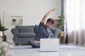 Middle age woman smiling happy doing exercise and stretching in living room at home Royalty Free Stock Photo