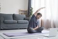 Middle age woman smiling happy doing exercise and stretching in living room at home Royalty Free Stock Photo