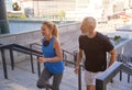 Active middle aged couple in sportswear running up a flight of stairs in city while working out together outdoors Royalty Free Stock Photo