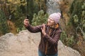 An active middle-aged woman takes selfie with her smartphone while hiking in the mountains through the forest. Close up Royalty Free Stock Photo