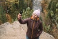 An active middle-aged woman takes selfie with her smartphone while hiking in the mountains through the forest. Close up Royalty Free Stock Photo