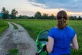 Active mom pushing a stroller at sunset.