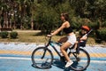 Active mother and child riding a bike together on outdoors background. Caucasian woman and baby boy on a bicycle Royalty Free Stock Photo