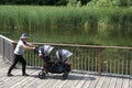 Active mother wearing a hat pushing a baby stroller in the park