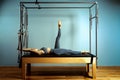 Active motivated woman does exercises in bed reformer, beauty and health. Plastic, posture, smart fitness.