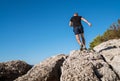 Active mountain skyrunner dressed black t-shirt and running shoes jogging the cliff summit during the morning scamper. Sporty