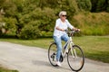 Happy senior woman riding bicycle at summer park Royalty Free Stock Photo