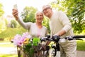 Senior couple with bicycles taking selfie at park Royalty Free Stock Photo