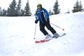 Active old aged senior experienced mature skier man in ski helmet, goggles, suit riding skies mountain peak, slope