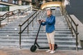 Active old woman riding electric scooter. Retired lady uses environmentally friendly city vehicle. Granny very old with Royalty Free Stock Photo