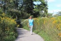 Active older woman walks for exercise in natural setting