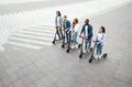 Five friends having pleasant ride on electric kick scooters Royalty Free Stock Photo