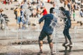 Active people in the city. Young man and woman enjoing in a city fountain over crowded background. Selective focus