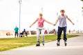 Young couple rollerblading in park holding hands. Royalty Free Stock Photo