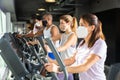 Active people in protective masks having running elliptical trainer class in club