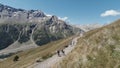 Active people walking up on the mountain trail. Clip. Group of hikers exploring breathtaking summer trail on rocks and Royalty Free Stock Photo