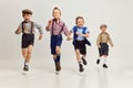 Active, playful boys, children in stylish clothes with suspenders playing together, running over grey studio background Royalty Free Stock Photo