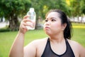 Active plus size woman hydration drinking a water bottle outdoors, taking a break during a sunny day exercise routine. Royalty Free Stock Photo