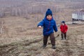 Active preschool children climb the path to the high mountain in spring, spring landscape