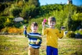 Active preschool girl and boy playing badminton in outdoor court in summer. Kids play tennis. School sports for children. Racquet