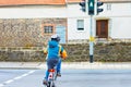 Active preschool kid boy in helmet biking on bicycle in the city. Happy child in colorful clothes and driving on green