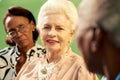 Group of elderly black and caucasian women talking in park