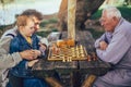 Senior men having fun and playing chess at park Royalty Free Stock Photo