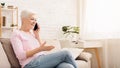 Cheerful senior woman talking with client oh phone Royalty Free Stock Photo