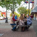 Active retirement, old people and seniors free time, group of four elderly men having fun and playing cards game at park Royalty Free Stock Photo