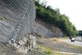 Active robust rockfall barrier system with wire mesh along the road, brake for rocks fall.